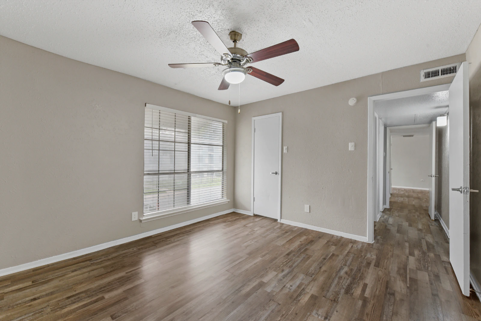 Villa Encanto bedroom with wood-look flooring, a window, and ceiling fan