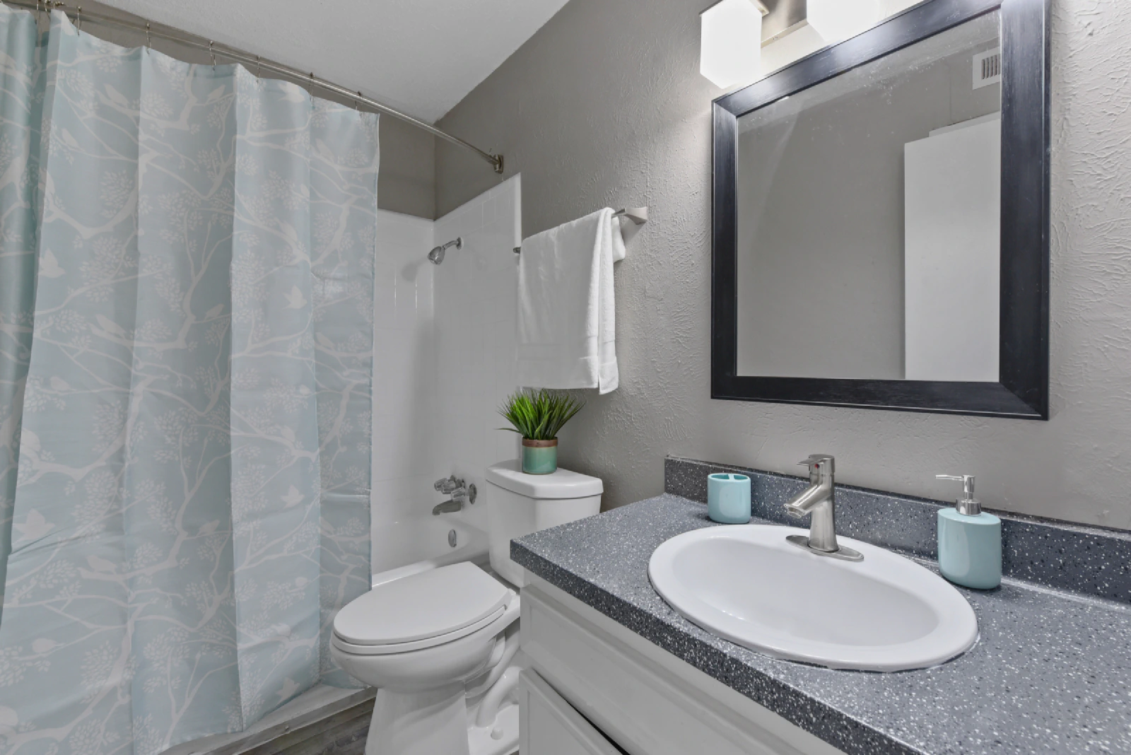 Villa Encanto bathroom with tub and shower, vanity, and framed mirror